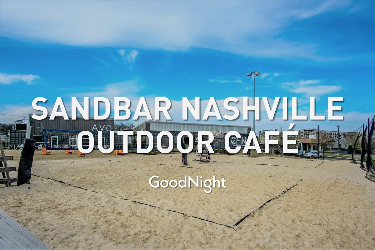 An inviting exterior shot of a sand volleyball court adjacent to an outdoor café, with people dining, playing, and mingling under the open sky. The setting sun and string lights add a festive, relaxed mood, evoking the idea of seasonal events, outdoor meals, and live music nights.
