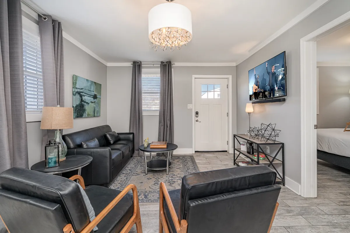 A comfortable living area with a sofa, stylish artwork, a coffee table, a TV, and a warm lamp—providing a cozy setting ideal for relaxing, watching TV, or spending time with friends and family.